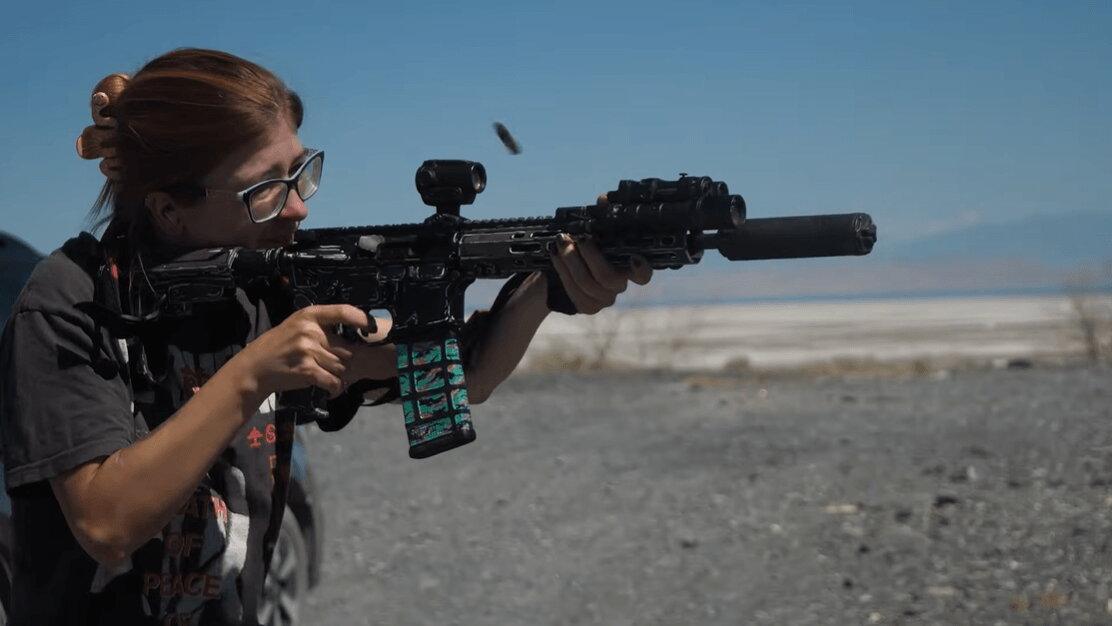 Shooter firing suppressed AR-15 at range