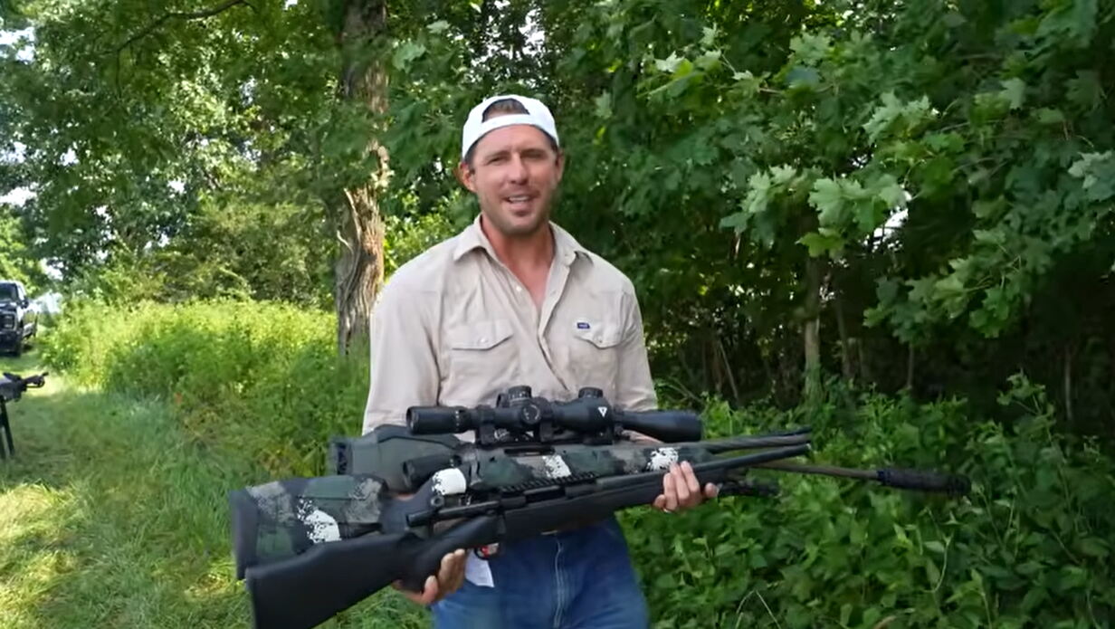 Host holding two scoped bolt-action rifles