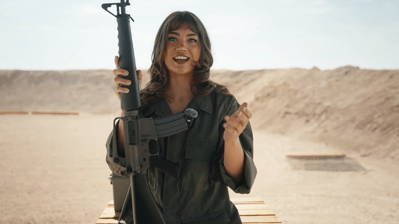 Lujan holding M16-pattern rifle at range